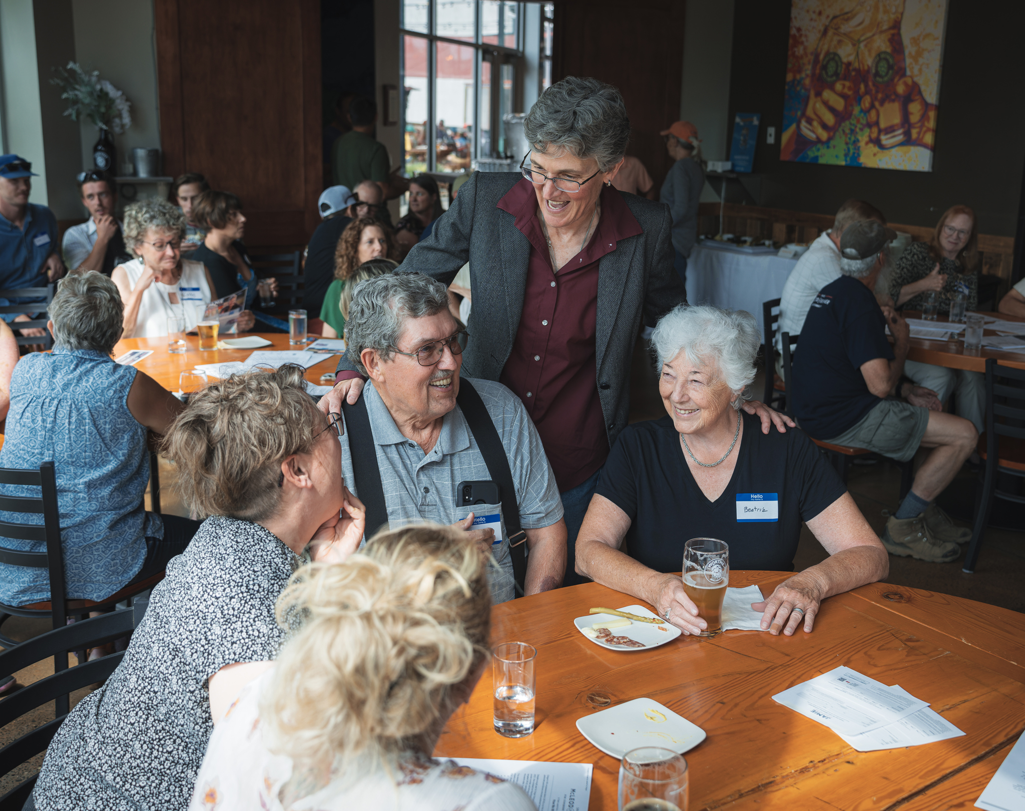 Jamie McLeod-Skinner chats with seated supporters at an event in Bend, OR in 2023.